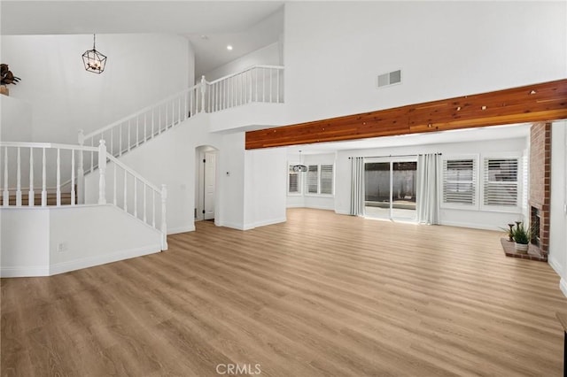 5731 Applecross Dr, Riverside, CA 92507 - unfurnished living room with a high ceiling, wood finished floors, stairway, arched walkways, and recessed lighting