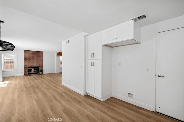 5731 Applecross Dr, Riverside, CA 92507 - unfurnished living room with light wood-style flooring and a brick fireplace