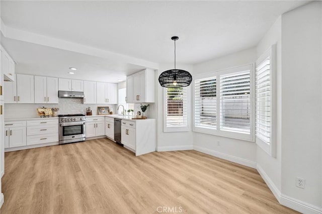 5731 Applecross Dr, Riverside, CA 92507 - kitchen with appliances with stainless steel finishes, under cabinet range hood, light wood finished floors, white cabinets, and a chandelier