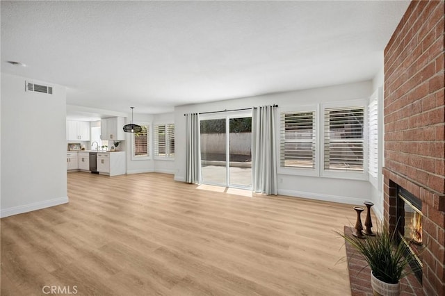 5731 Applecross Dr, Riverside, CA 92507 - unfurnished living room with a fireplace and light wood-style floors
