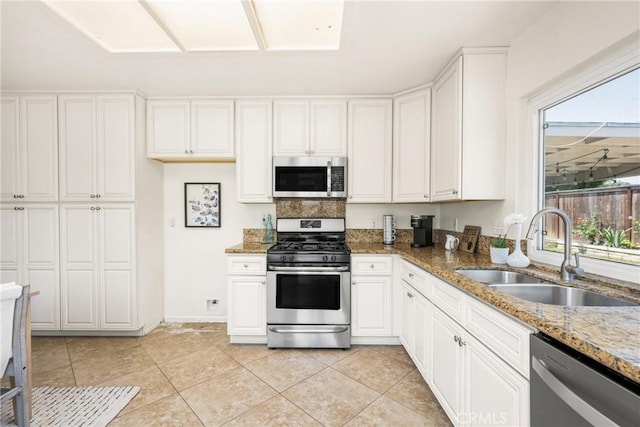 22811 Fortuna Ln, Mission Viejo, CA 92691 - kitchen with appliances with stainless steel finishes, light stone countertops, white cabinetry, and light tile patterned floors