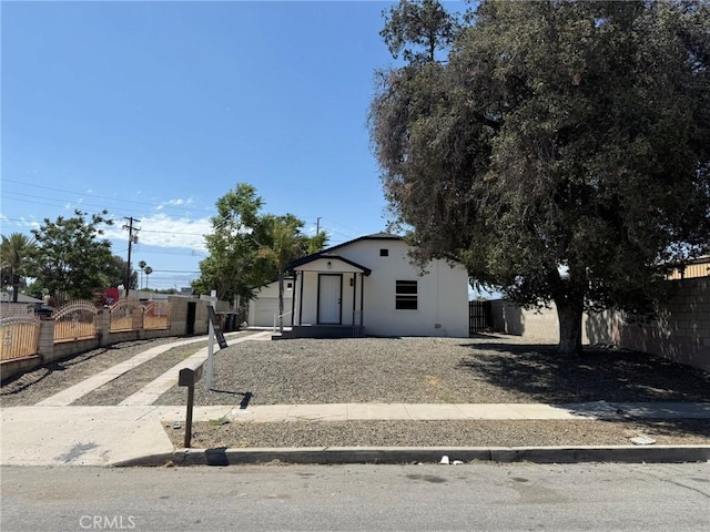 817 Orange Grove Ave, Colton, CA 92324 - view of front facade with a fenced front yard, stucco siding, driveway, and a gate