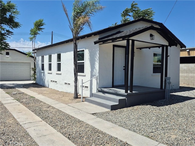 817 Orange Grove Ave, Colton, CA 92324 - view of front of house with stucco siding, an outbuilding, a detached garage, and crawl space