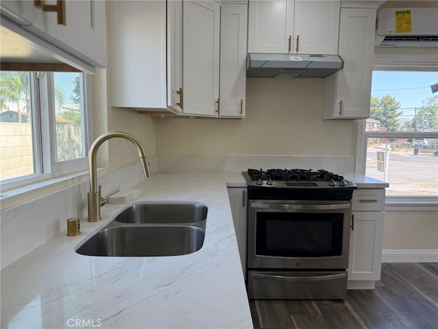 817 Orange Grove Ave, Colton, CA 92324 - kitchen featuring stainless steel gas stove, under cabinet range hood, a wall mounted AC, light stone counters, and dark wood-type flooring