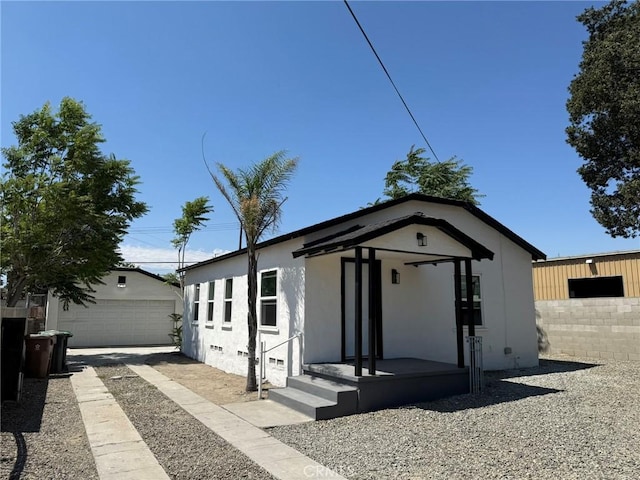 817 Orange Grove Ave, Colton, CA 92324 - view of front of home with an outdoor structure, a garage, and stucco siding