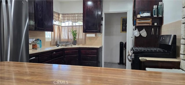 6718 Del Rosa Dr, San Bernardino, CA 92404 - kitchen with black gas stove, backsplash, and light countertops