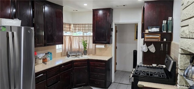 6718 Del Rosa Dr, San Bernardino, CA 92404 - kitchen with freestanding refrigerator, black gas stove, light countertops, and decorative backsplash