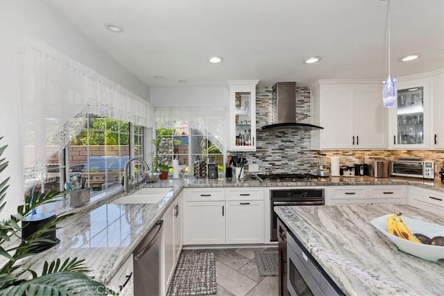 1110 Norcrest St, Corona, CA 92878 - kitchen featuring wall chimney range hood, stainless steel appliances, white cabinetry, tasteful backsplash, and light stone countertops