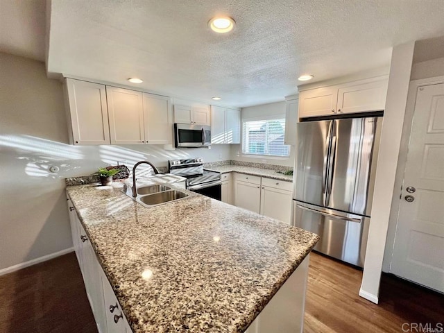 8733 Lake Murray Blvd Unit 6, San Diego, CA 92119 - kitchen featuring appliances with stainless steel finishes, a peninsula, white cabinetry, light stone counters, and recessed lighting