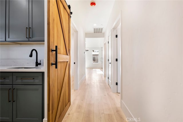 6779 Matell Rd, Paradise, CA 95969 - hallway featuring a barn door and light wood-style flooring