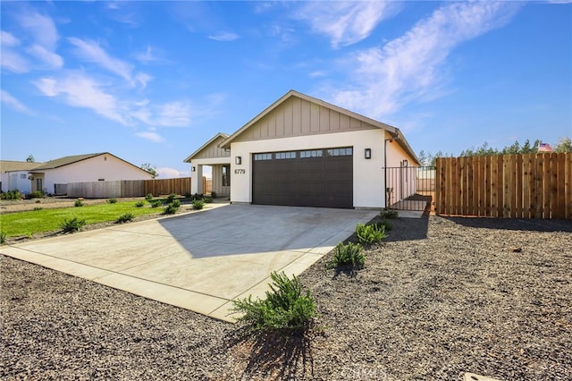 6779 Matell Rd, Paradise, CA 95969 - view of front of house featuring board and batten siding, driveway, an attached garage, and a gate