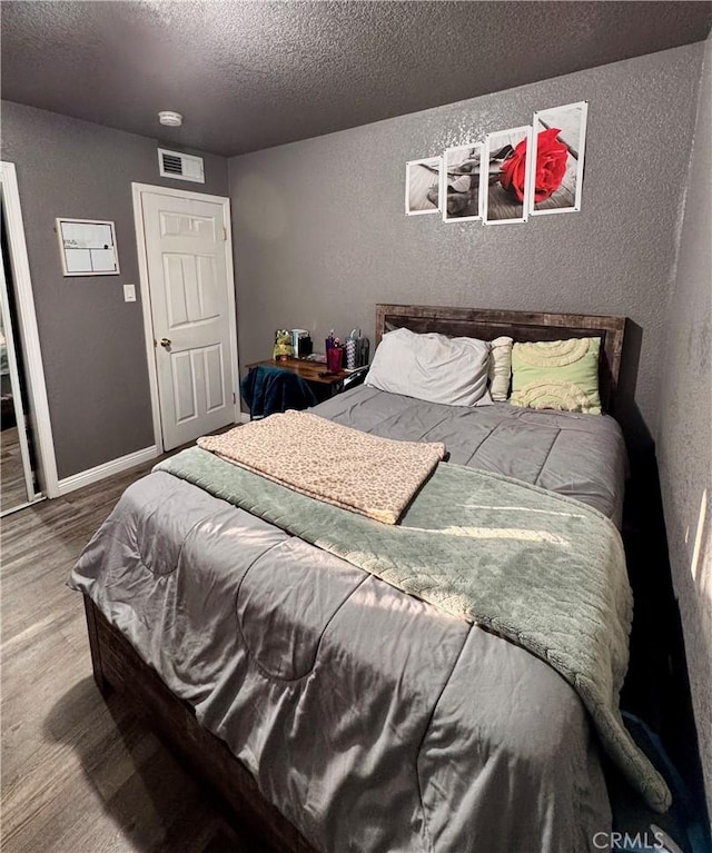 751 Yucca Ave, Barstow, CA 92311 - bedroom with a textured ceiling, a textured wall, and wood finished floors