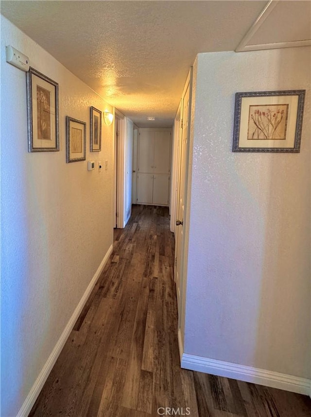 751 Yucca Ave, Barstow, CA 92311 - hallway with a textured ceiling and dark wood-style flooring