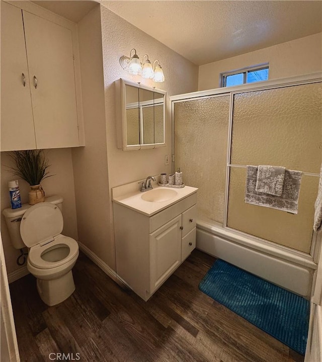 751 Yucca Ave, Barstow, CA 92311 - bathroom with wood finished floors, vanity, a textured wall, combined bath / shower with glass door, and a textured ceiling