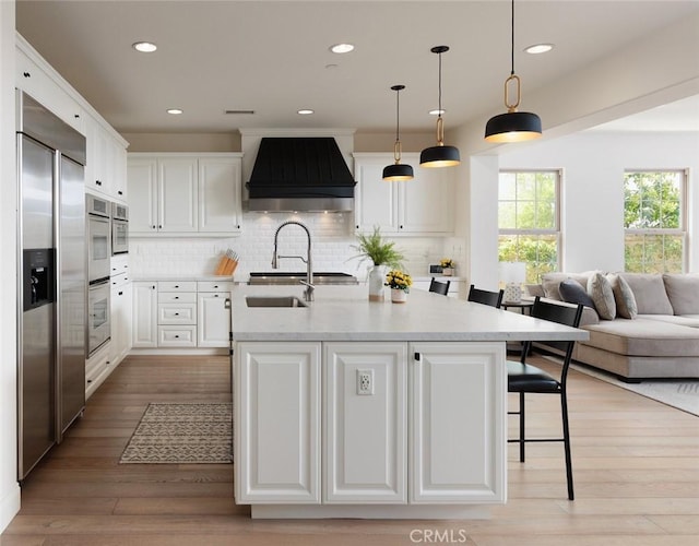 21 Via Nerisa, San Clemente, CA 92673 - kitchen featuring custom range hood, built in refrigerator, white cabinetry, open floor plan, and backsplash