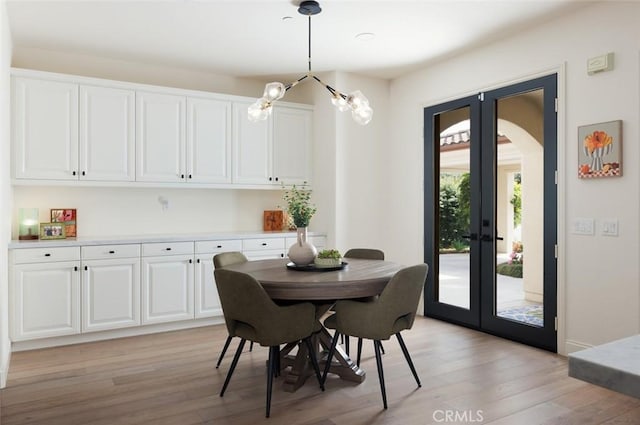 21 Via Nerisa, San Clemente, CA 92673 - dining room featuring french doors, light wood finished floors, a chandelier, and arched walkways