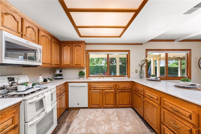 1128 Aldersgate Dr, La Verne, CA 91750 - kitchen with white appliances, brown cabinets, light countertops, and light wood-style floors