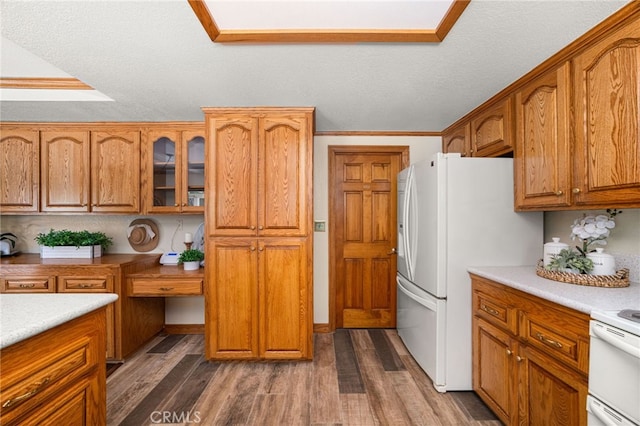 1128 Aldersgate Dr, La Verne, CA 91750 - kitchen with brown cabinetry, dark wood-type flooring, white appliances, and ornamental molding