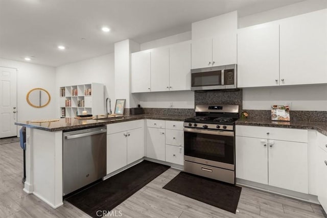 15958 Lasselle St Unit 2, Moreno Valley, CA 92551 - kitchen with stainless steel appliances, a peninsula, white cabinetry, light wood finished floors, and recessed lighting