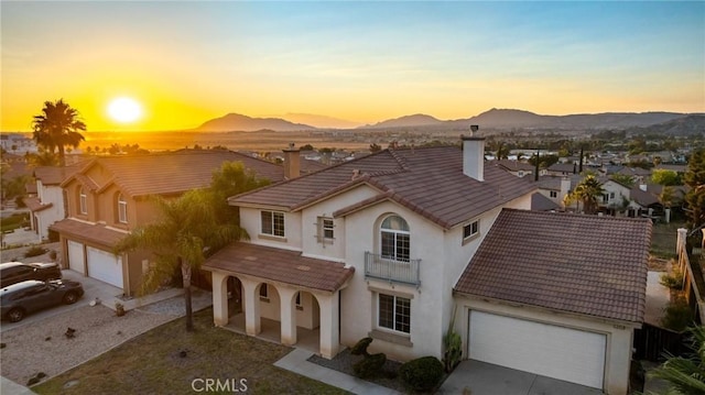 15453 La Casa Dr, Moreno Valley, CA 92555 - mediterranean / spanish-style home with a chimney, a tiled roof, concrete driveway, a mountain view, and stucco siding