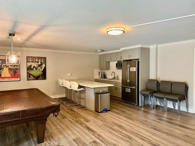330 W California Blvd Unit 101, Pasadena, CA 91105 - kitchen with stainless steel appliances, light countertops, gray cabinets, wood finished floors, and a kitchen breakfast bar