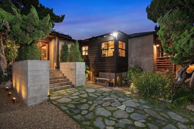 860 Nardo Rd, Encinitas, CA 92024 - back of house at dusk featuring stairs and a patio area