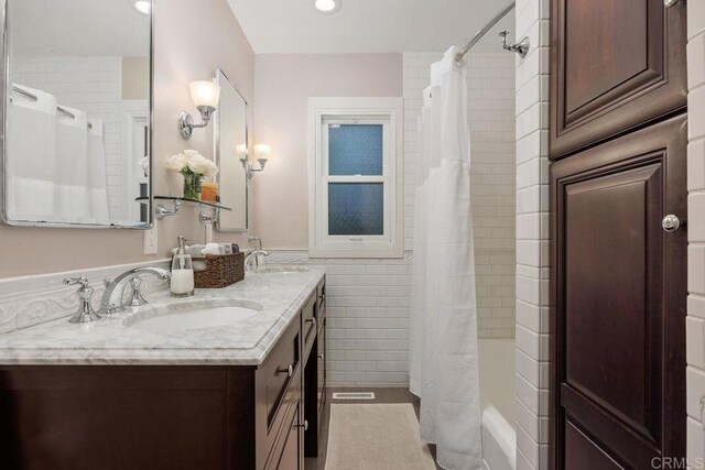 860 Nardo Rd, Encinitas, CA 92024 - full bathroom with tile walls, double vanity, shower / bath combination with curtain, and a wainscoted wall
