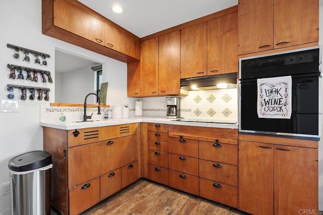 860 Nardo Rd, Encinitas, CA 92024 - kitchen with black appliances, under cabinet range hood, backsplash, and brown cabinetry