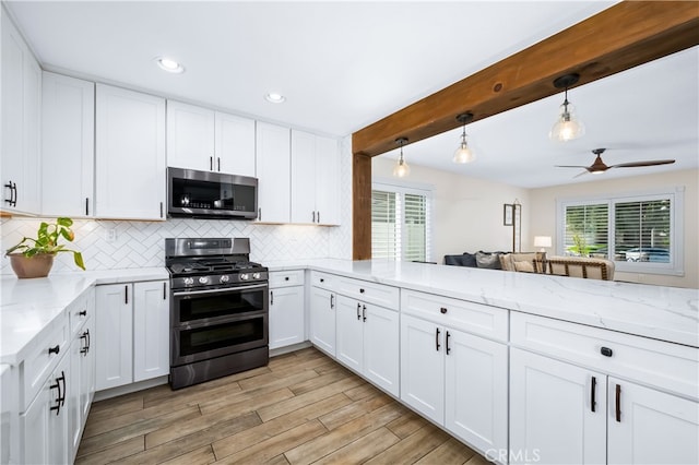 33037 Paterno St, Temecula, CA 92592 - kitchen with stainless steel microwave, range with two ovens, healthy amount of natural light, backsplash, and beamed ceiling