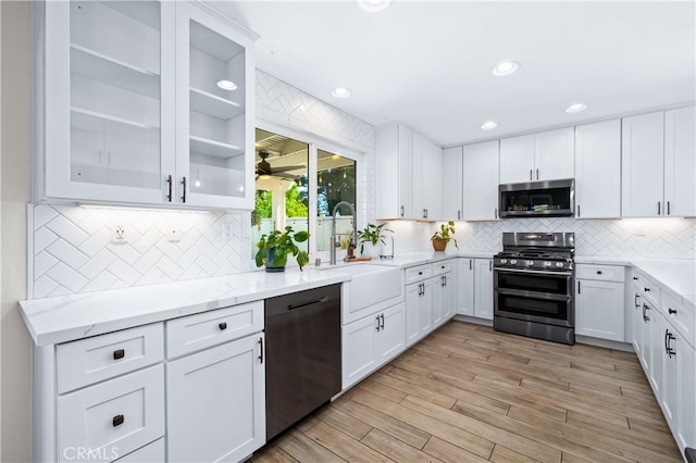 33037 Paterno St, Temecula, CA 92592 - kitchen with stainless steel appliances, tasteful backsplash, white cabinets, light wood finished floors, and recessed lighting