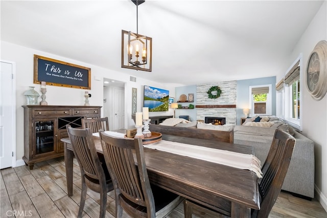 33037 Paterno St, Temecula, CA 92592 - dining space with wood finished floors, a fireplace, and a chandelier