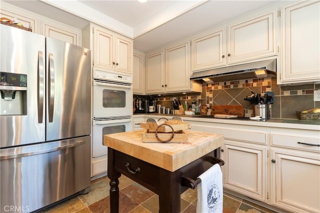 31032 Via Estenaga, San Juan Capistrano, CA 92675 - kitchen featuring stainless steel refrigerator with ice dispenser, double oven, under cabinet range hood, and backsplash
