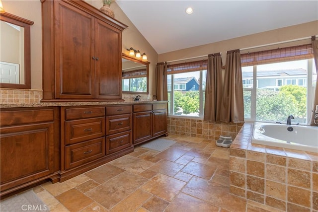 31032 Via Estenaga, San Juan Capistrano, CA 92675 - full bathroom featuring double vanity, stone tile flooring, lofted ceiling, a bath, and recessed lighting