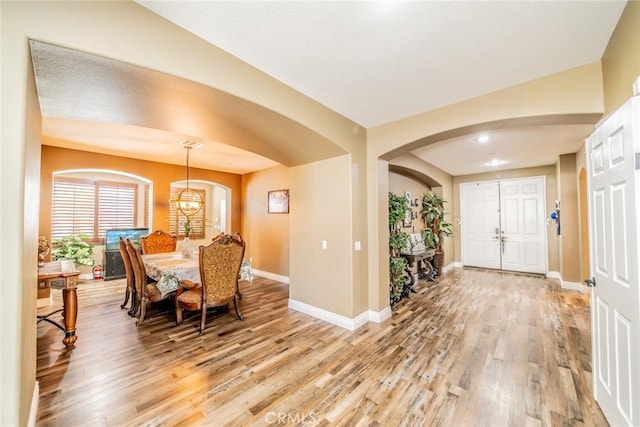 29155 Celestial Dr, Menifee, CA 92584 - foyer with light wood-type flooring, arched walkways, and a chandelier