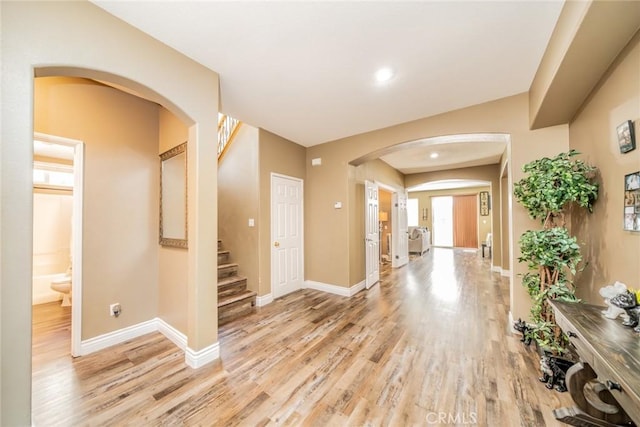 29155 Celestial Dr, Menifee, CA 92584 - corridor featuring arched walkways, light wood-style floors, and stairs