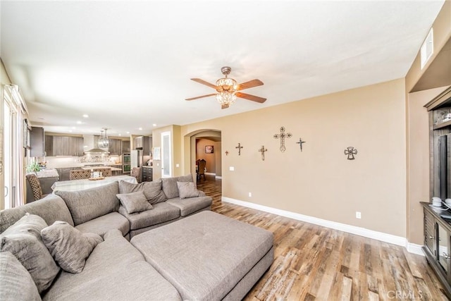 29155 Celestial Dr, Menifee, CA 92584 - living room with arched walkways, light wood-style floors, a ceiling fan, and recessed lighting