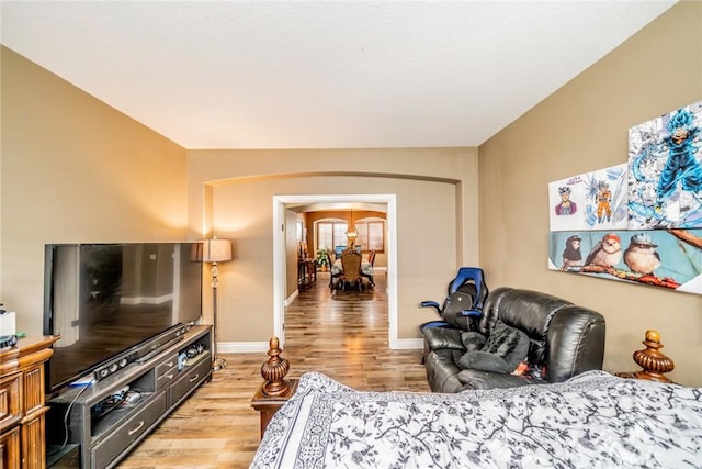 29155 Celestial Dr, Menifee, CA 92584 - bedroom with arched walkways and light wood-style flooring