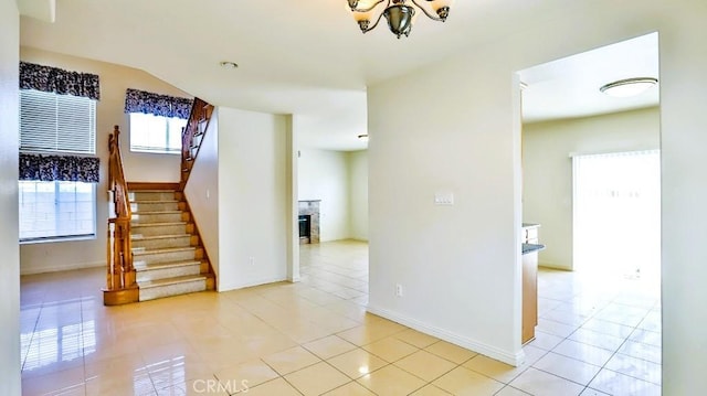 15537 Pheasant St, Chino Hills, CA 91709 - stairs featuring a chandelier, tile patterned floors, and a glass covered fireplace