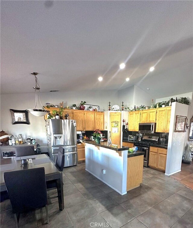 12649 Mesa Linda Ave, Victorville, CA 92392 - kitchen with stainless steel appliances, dark countertops, vaulted ceiling, a center island, and decorative backsplash