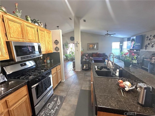 12649 Mesa Linda Ave, Victorville, CA 92392 - kitchen featuring appliances with stainless steel finishes, a ceiling fan, open floor plan, lofted ceiling, and dark countertops
