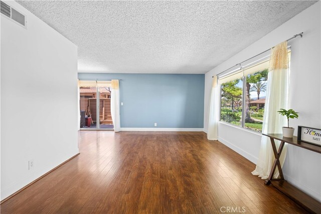 1456 Countrywood Ave Unit 14, Hacienda Heights, CA 91745 - unfurnished living room with a textured ceiling, wood finished floors, and plenty of natural light