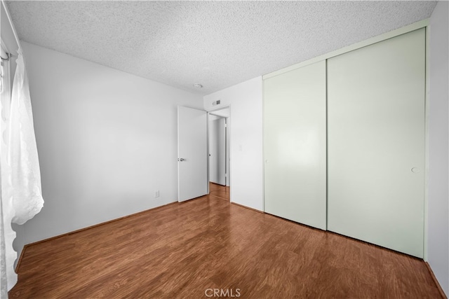 1456 Countrywood Ave Unit 14, Hacienda Heights, CA 91745 - unfurnished bedroom featuring a textured ceiling, wood finished floors, and a closet