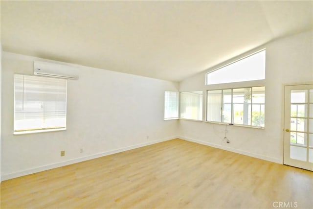 18431 Dancy St, Rowland Heights, CA 91748 - empty room with a wall mounted air conditioner, light wood finished floors, and high vaulted ceiling