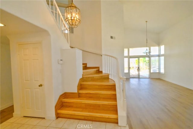 18431 Dancy St, Rowland Heights, CA 91748 - stairs featuring a chandelier, a towering ceiling, and wood finished floors