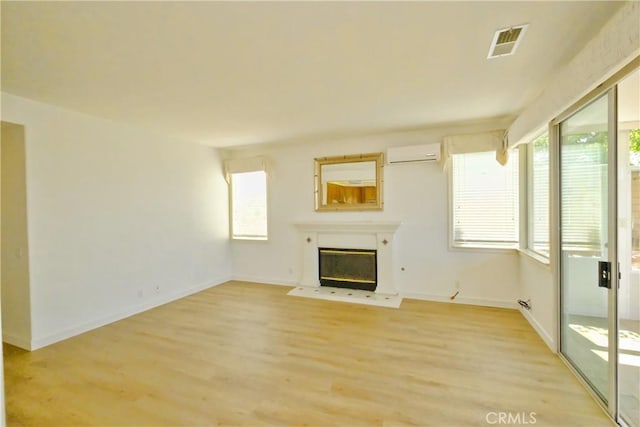 18431 Dancy St, Rowland Heights, CA 91748 - unfurnished living room with an AC wall unit, healthy amount of natural light, light wood finished floors, and a glass covered fireplace