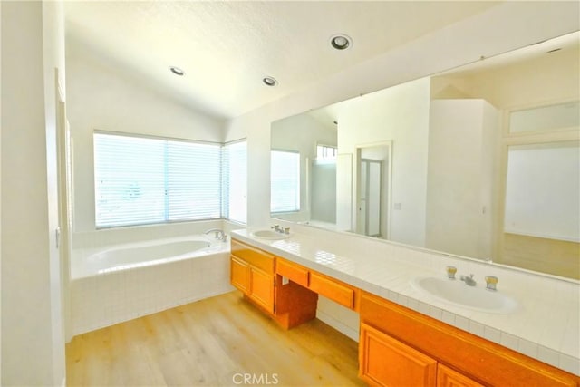 18431 Dancy St, Rowland Heights, CA 91748 - full bathroom with wood finished floors, a bath, double vanity, and vaulted ceiling