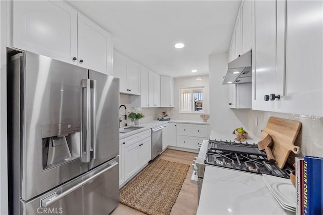 13141 Willamette St, Westminster, CA 92683 - kitchen with stainless steel appliances, light wood-style flooring, white cabinetry, light stone countertops, and under cabinet range hood