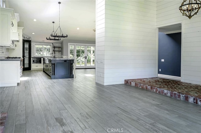 777 Oak Knoll St, Brea, CA 92821 - kitchen featuring a chandelier, white cabinetry, wood finished floors, an island with sink, and pendant lighting