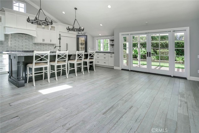 777 Oak Knoll St, Brea, CA 92821 - kitchen with a chandelier, decorative backsplash, white cabinetry, a center island with sink, and light countertops