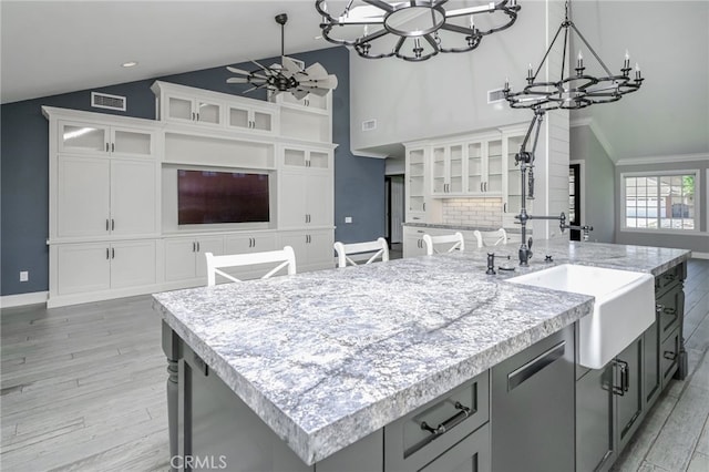 777 Oak Knoll St, Brea, CA 92821 - kitchen featuring a chandelier, light countertops, a center island with sink, light wood finished floors, and high vaulted ceiling